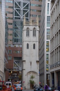 A bell tower from an early church, among modern buildings